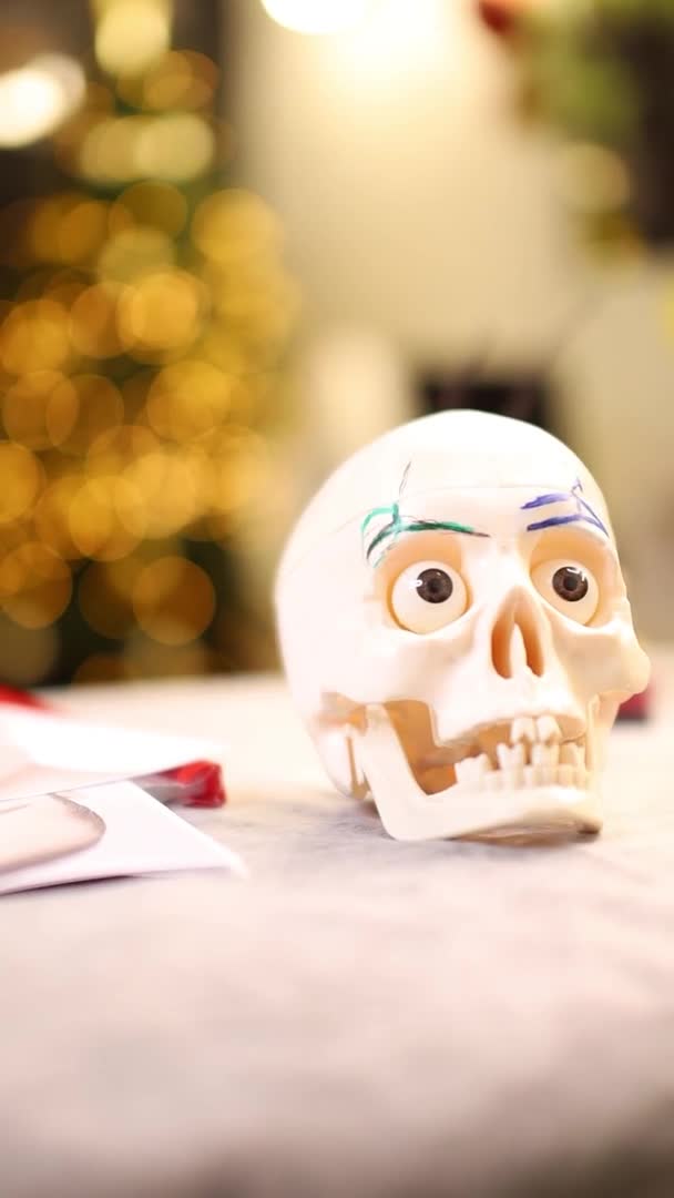 Maqueta de un cráneo de esqueleto humano en el fondo de un árbol de Navidad — Vídeo de stock