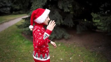 Noel geyiği ve Noel şapkalı kırmızı örülü Noel süveteri giyen çocuk.