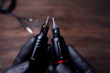 Kalıcı makyaj kartuşu takan dövme makinelerinin yakın çekimi.