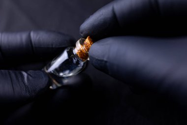 Ustanın ellerinde kaşlara uygulanması için bir şişe argan yağı var.