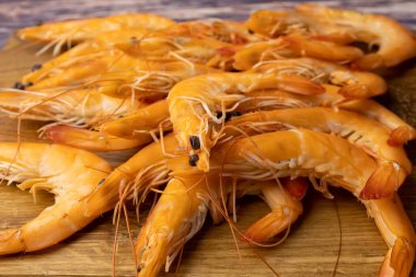 Ahşap tezgahta bir sürü haşlanmış karides.