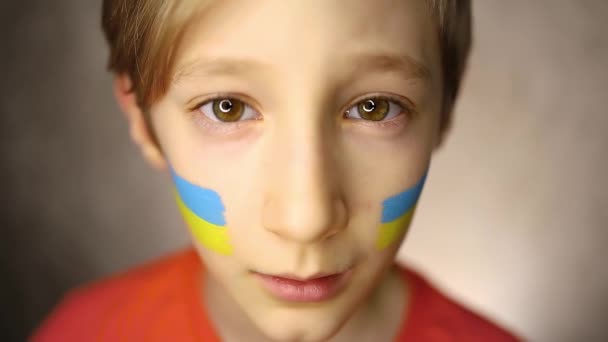 Savaşa Karşı Bir Çocuk Gözyaşı Lekeli Gözleri Yanaklarında Ukrayna Bayrağı — Stok video