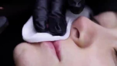 Modelin dudaklarındaki usta dudak dövmesi yapar ve dudakların kalıcı makyajını yapar.