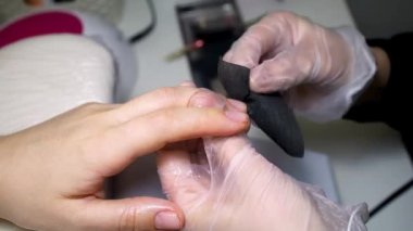 Manikür ustası işlemden önce çiviyi siyah bir peçeteyle korur.