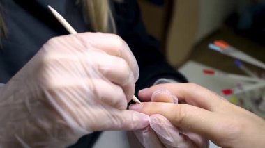 Manikür ustası, işlemden önce çiviyi tahta bir sopayla korur.