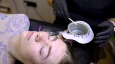 Kalıcı kaş makyajı prosedüründen sonra usta, kaş çevresindeki kılları çıkarmak için ağda prosedürünü uygular.