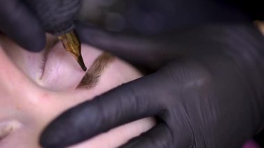 Bir kız modelin kaş makyajına taruage sürüyorum.