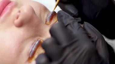 Gözlerde silia tabakası var. Usta mendiller kirpik boyası sürerek yayıyor. 