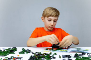 Çocuk plastik yapımcısıyla oynuyor. Detayları birbirine bağlıyor.