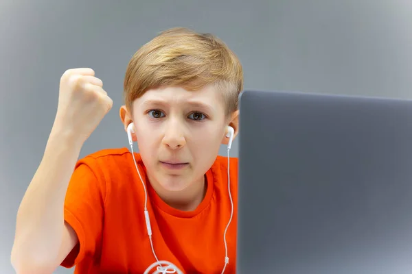 Мальчик Ноутбуком Смотрит Камеру Угрожающе Показывает Кулаком — стоковое фото
