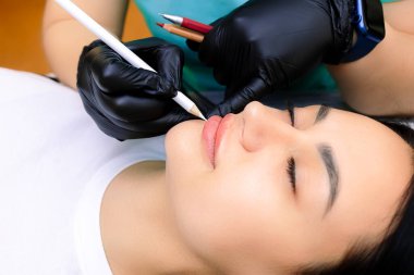 Kalıcı makyajın ustası dudaklara beyaz bir kalemle işaret koyar