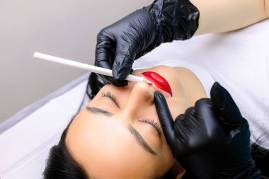 Dudakların kalıcı makyajından önce, usta zaten yapılmış olan dudakları yuvarlak içine alır ve çevreye beyaz bir çizgi çizer.