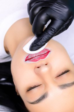 Usta, kalıcı dudak makyajından önce dudaklara özel bir pudra sürer.