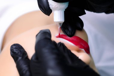 Makro fotoğrafçılık dudakların köşeleriyle çalışır. Kalıcı makyaj ustası daktiloyla dövme yapar.