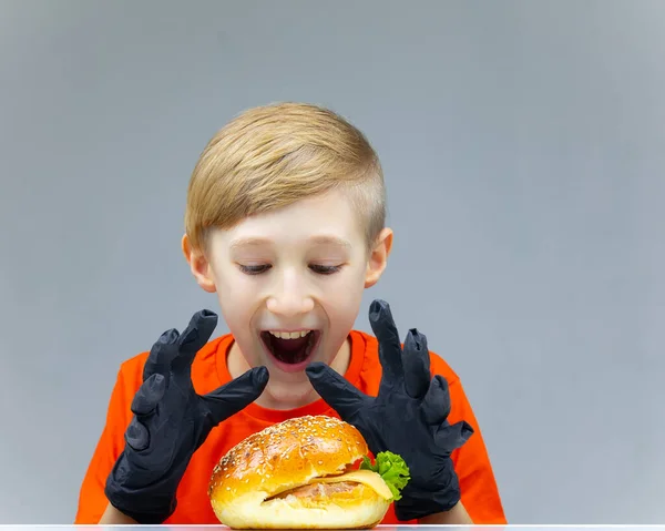 Ragazzo Con Cheeseburger Tavola Felicemente Vuole Afferrarlo Sedersi — Foto Stock