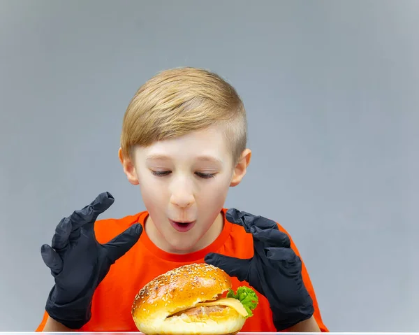 Ein Junge Mit Einem Cheeseburger Schaut Ihn Und Ihn Die — Stockfoto