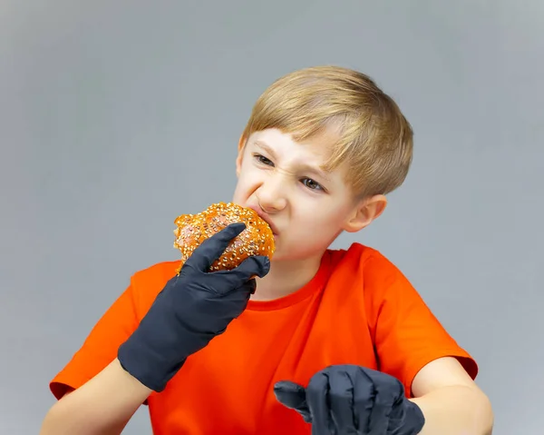 Çocuk Masada Oturan Dev Bir Hamburgerin Artıklarını Yiyor — Stok fotoğraf