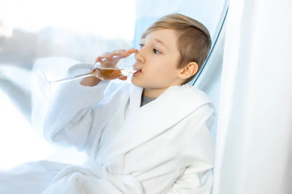 Ребенок Держит Перед Собой Бокал Детского Безалкогольного Шампанского Пьет Сидя — стоковое фото