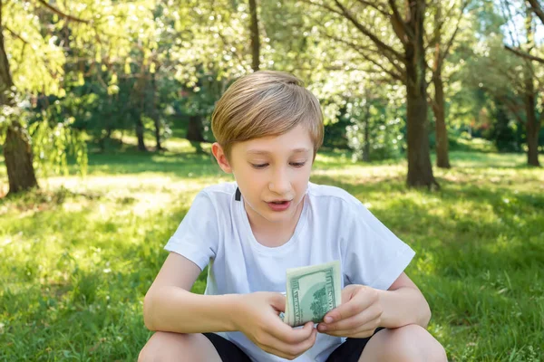 Een Jongen Het Park Telt Ijverig Dollarbiljetten Hurkt — Stockfoto