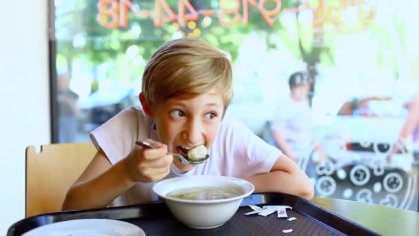 Мальчик Наклонился Над Миской Супа Ест Суп Кафе — стоковое видео