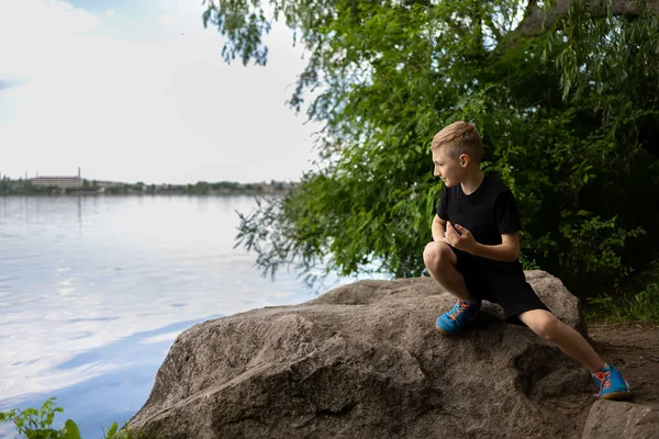 Ein Junge Blickt Den Fluss Der Auf Einem Stein Sitzt — Stockfoto
