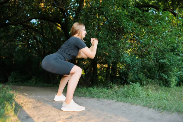 Slender Blonde Park Doing Squats Doing Fitness Outdoors — 图库照片