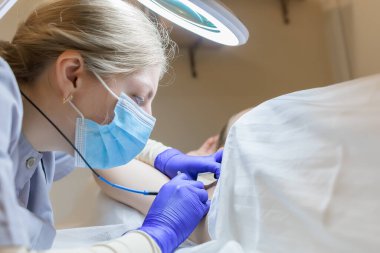doctor's work on electrolysis with tweezers and an electrode, he removes unwanted hairs