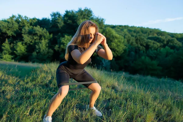 Fitness Blonde Doing Squats Rubber Bands Her Legs — 图库照片