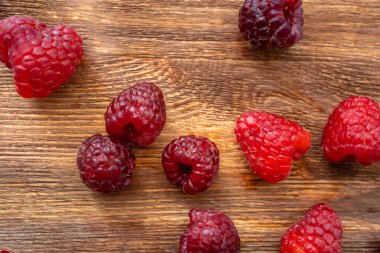 top view of berries scattered on a wooden table raspberries on the table