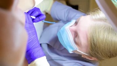 close-up of the face of an electrolysis doctor who performs a hair follicle removal procedure with electricity in the armpits