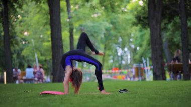 little athlete girl doing an acrobatic element, somersaulting with her hands