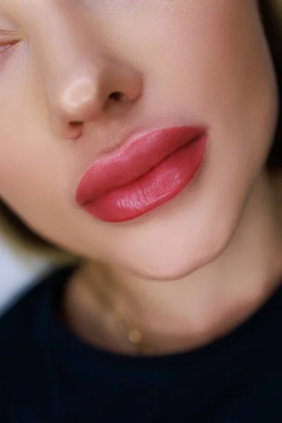 close-up of the lips of a beautiful girl model with the work done on the permanent make-up of the lips