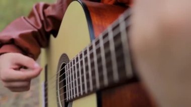 Gitar tellerinin altında atan bir çocuğun yakın çekimi.