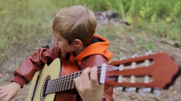秋天的时候 男孩在森林里弹吉他弹得很厉害 — 图库视频影像