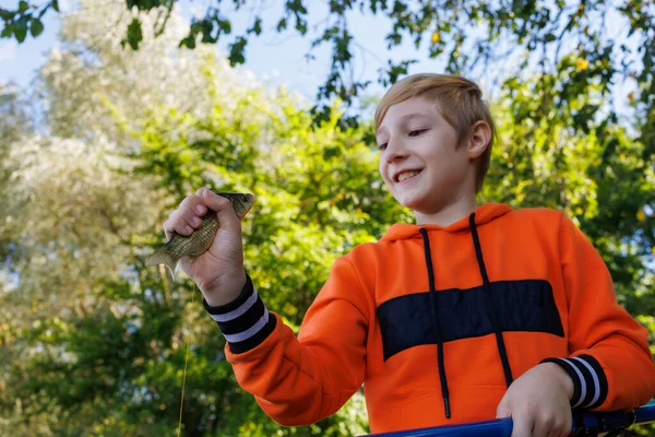 Boy Holds Fish Caught His Hands Looks Backdrop Forest — Stock Photo, Image