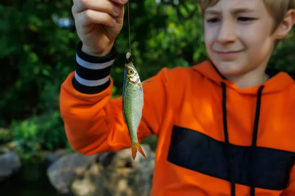 Close Small Fish Boy Caught Holds Front Him Hook — Stock Photo, Image