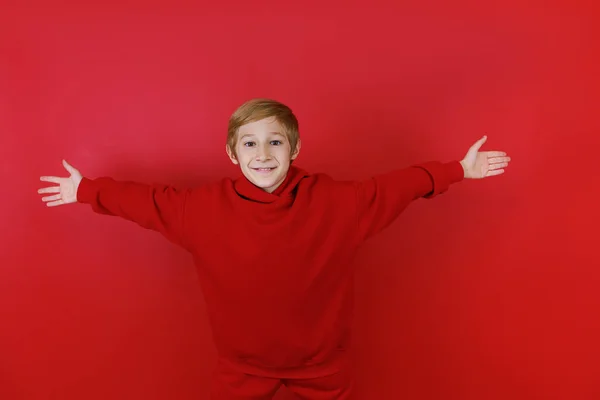 Wesoły Chłopiec Czerwonym Tle Ubrany Czerwony Garnitur Wyciągnął Ręce Boki — Zdjęcie stockowe