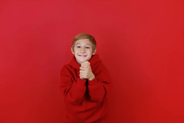 Chłopiec Czerwonym Garniturze Czerwonym Tle Złożył Ręce Przed Sobą — Zdjęcie stockowe
