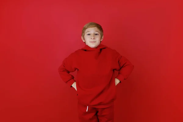 Stojąc Czerwonym Tle Chłopiec Ubrany Czerwony Dres Trzyma Ręce Pasku — Zdjęcie stockowe