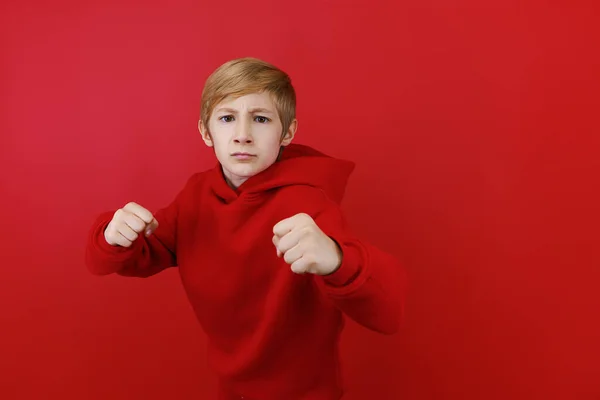 Röd Bakgrund Pojke Klädd Röd Träningsoverall Visar Hotfulla Tecken — Stockfoto