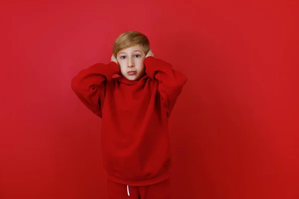 Czerwonym Tle Stoi Chłopiec Ubrany Czerwony Garnitur Złapał Się Głowę — Zdjęcie stockowe