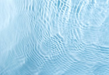 Bulanık mavi renkli su yüzeyi sıçrama ve kabarcıklarla kaplı.