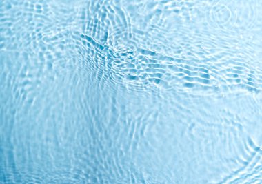 Bulanık mavi renkli su yüzeyi sıçrama ve kabarcıklarla kaplı.