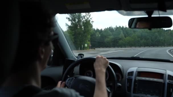 Man rijdt in een auto op een lege weg buiten de stad — Stockvideo