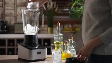 Blender 'da ezmek için buz hazırlayan kadın 