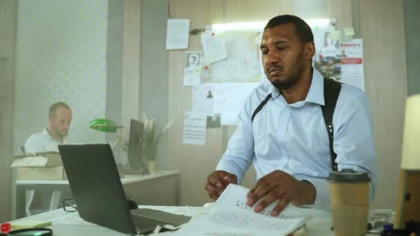 Handsome Male Detective Doing Paper Paper Work Typing Laptop While — Vídeo de stock