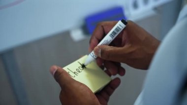 Handsome male detective writing on a sticker and sticking it on the map on the investigation board at police department. Policeman doing investigation compares clues on board.High quality 4k footage
