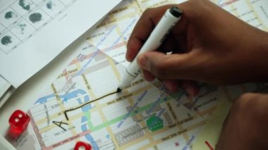 Hand draws a way from point a to b with a marker on the map. Investigator draws the way the criminal moves around the city on the map .High quality 4k footage