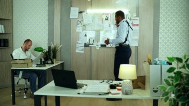 Handsome detective emotionally arguing on the phone about investigation. African american FBI agent or police officer has a call with a colleague discussing evidence of a crime.High quality 4k footage