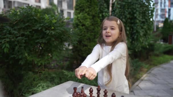 Cheerful Little Girl Offering Grandfather Choose Color Chess Piece Outdoor — ストック動画